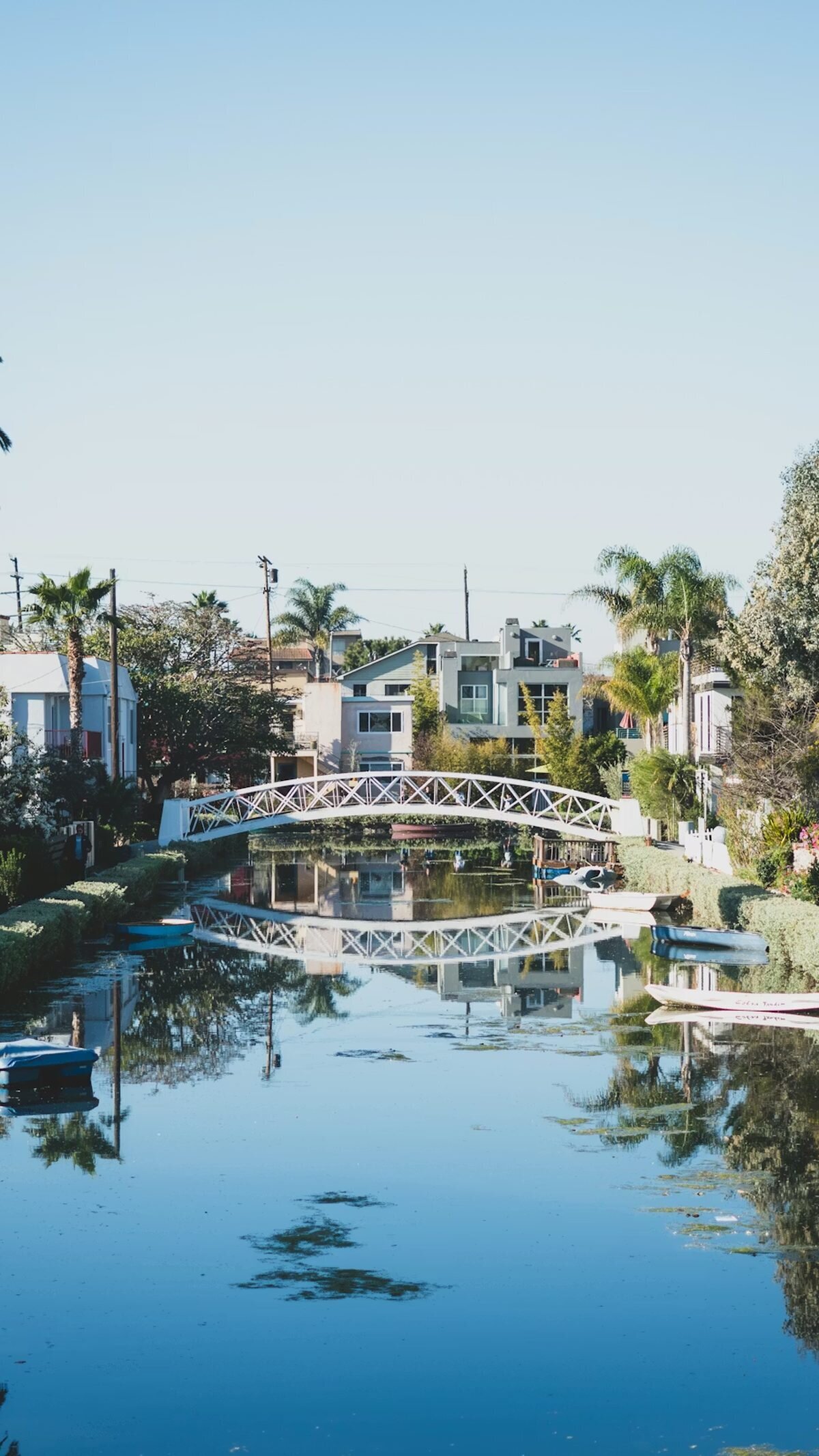 Los Angeles Engagement Photographer — Venice Canals White arched bridge reflected in the still water of the Venice Canals in Los Angeles, a charming location for engagement photos