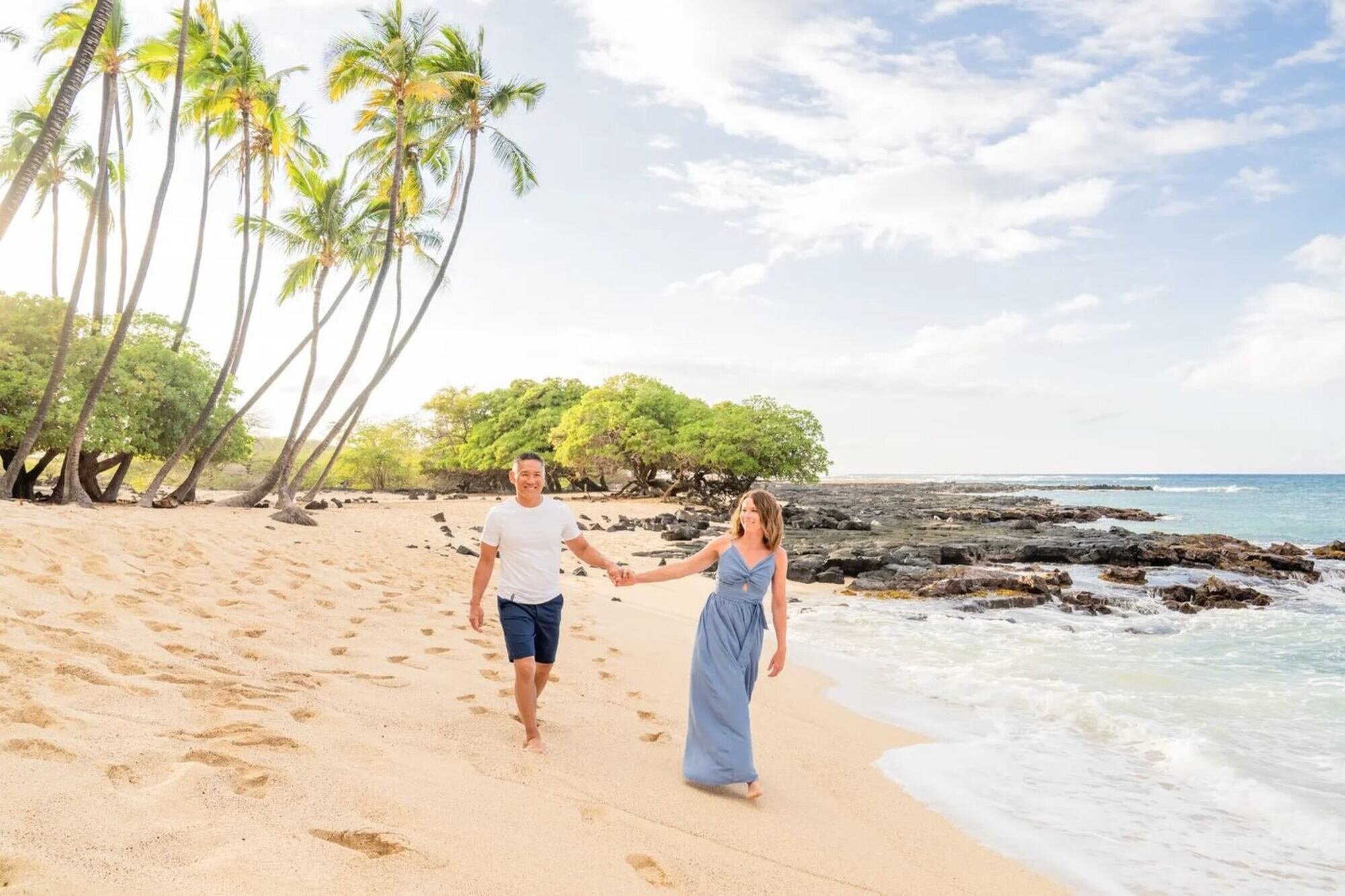 Couple Photoshoot on a Tropical Beach — Dreamgraphy A couple walking hand in hand along a tropical beach during a romantic vacation photoshoot