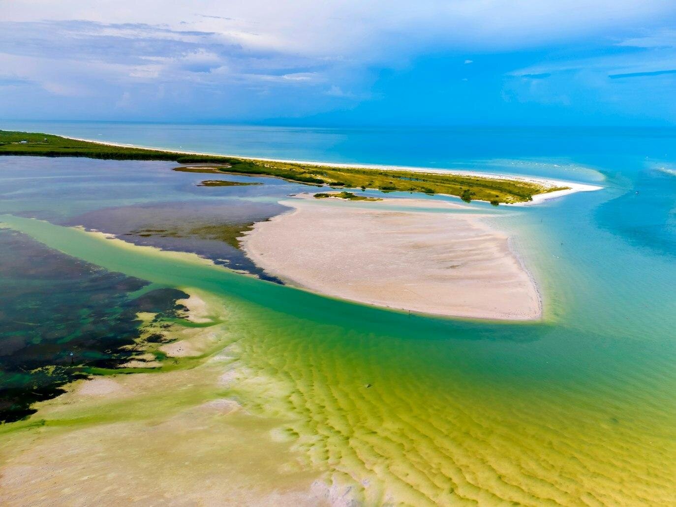 Tampa Photographer Locations | Caladesi Island State Park, Florida Aerial view of Caladesi Island State Park in Dunedin, Florida, showing the pristine white sandbar surrounded by turquoise and emerald Gulf waters — a secluded Tampa photo session location by Dreamgraphy