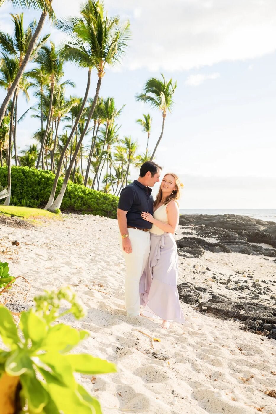 Couple Photoshoot Big Island Hawaii — Romantic Beach Portrait A couple embracing on a white sand beach on the Big Island of Hawaii surrounded by tall palm trees and soft golden light