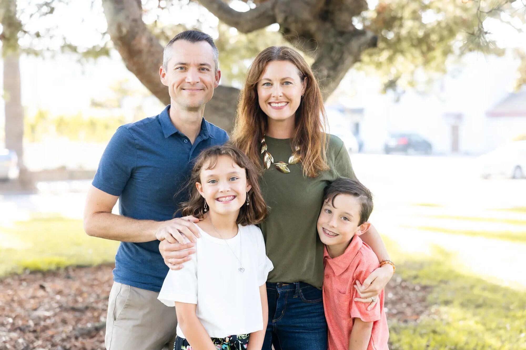 Los Angeles Family Photographer — Family Session at Seal Beach Los Angeles family photographer capturing a family of four with two school-age children smiling together under a large oak tree at Seal Beach in warm afternoon light