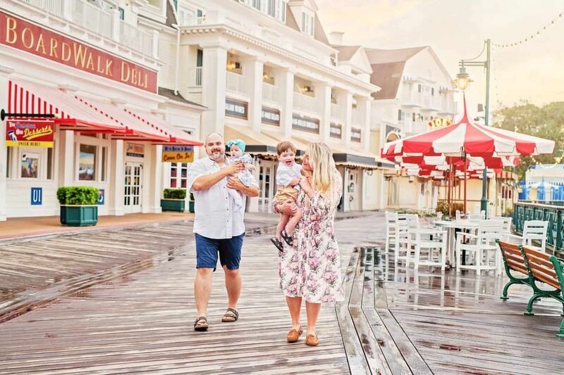 A family of four walking along the Disney Boardwalk in Orlando, captured by a professional Orlando family photographer during a resort session