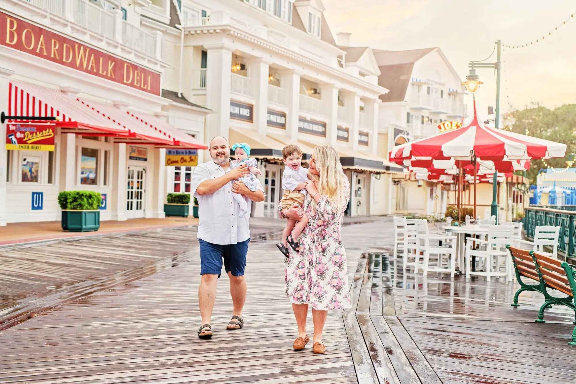 Family walking at Disney Boardwalk Family of four with two young children walking along the Disney Boardwalk Resort promenade
