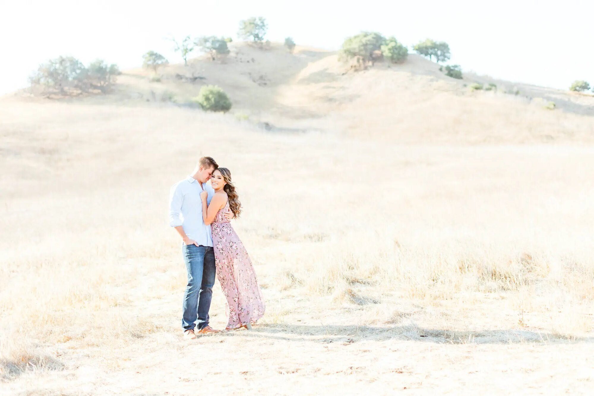 Los Angeles Engagement Photographer — Couple Session at Malibu Creek State Park An engaged couple embracing in the golden hills of Malibu Creek State Park during a Los Angeles engagement photography session by Dreamgraphy