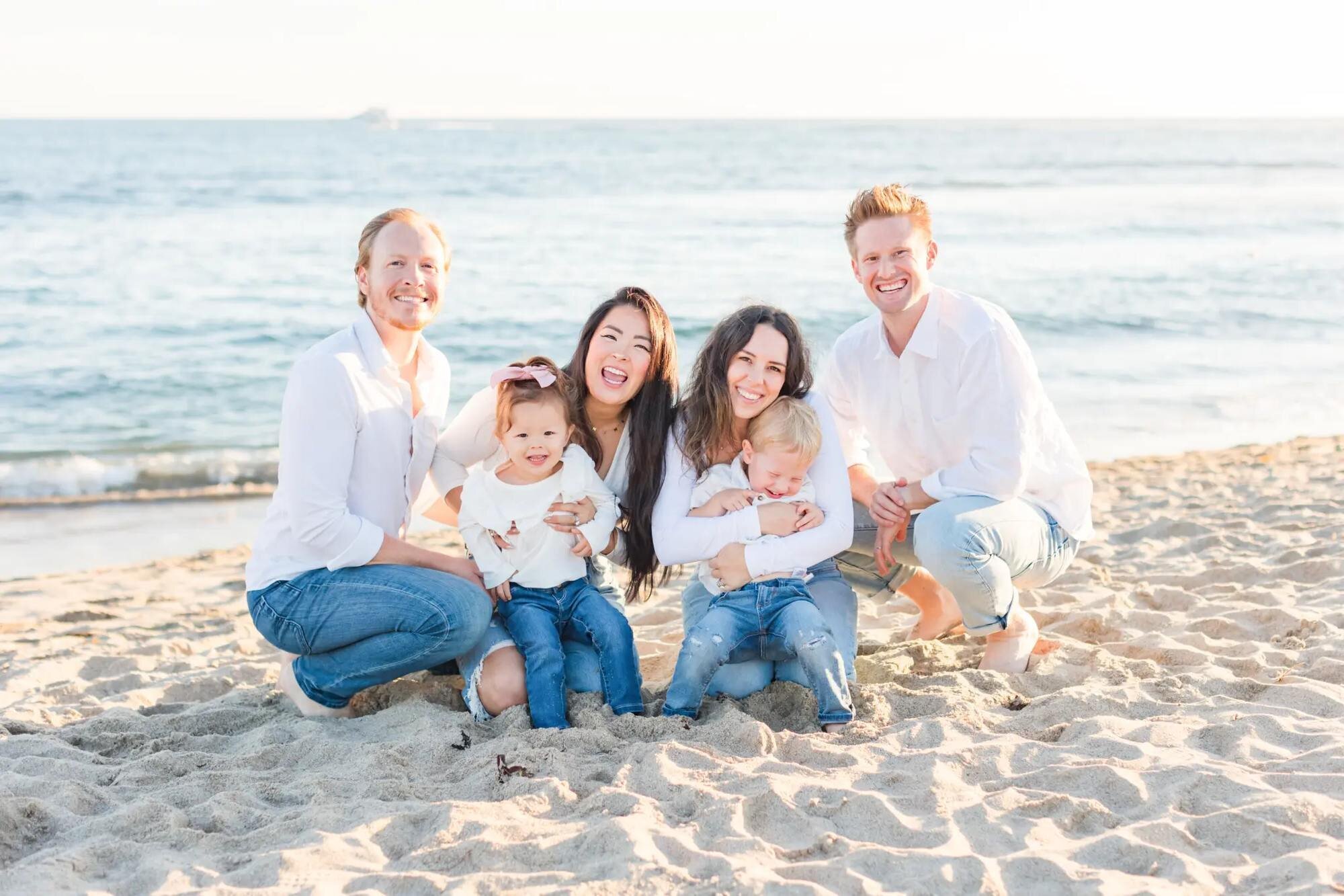 Los Angeles Family Photographer — Extended Family Session at Santa Monica Beach Los Angeles family photographer capturing two young families with toddlers and a newborn laughing together on the sand at Santa Monica Beach at golden hour