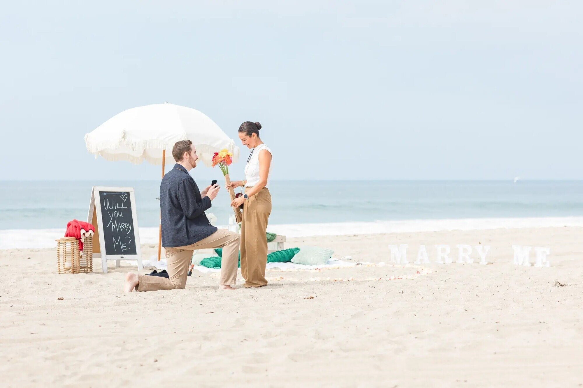 Los Angeles Engagement Photographer — Surprise Proposal at Santa Monica Beach A man on one knee proposing to his partner on Santa Monica Beach, captured by a Los Angeles engagement photographer