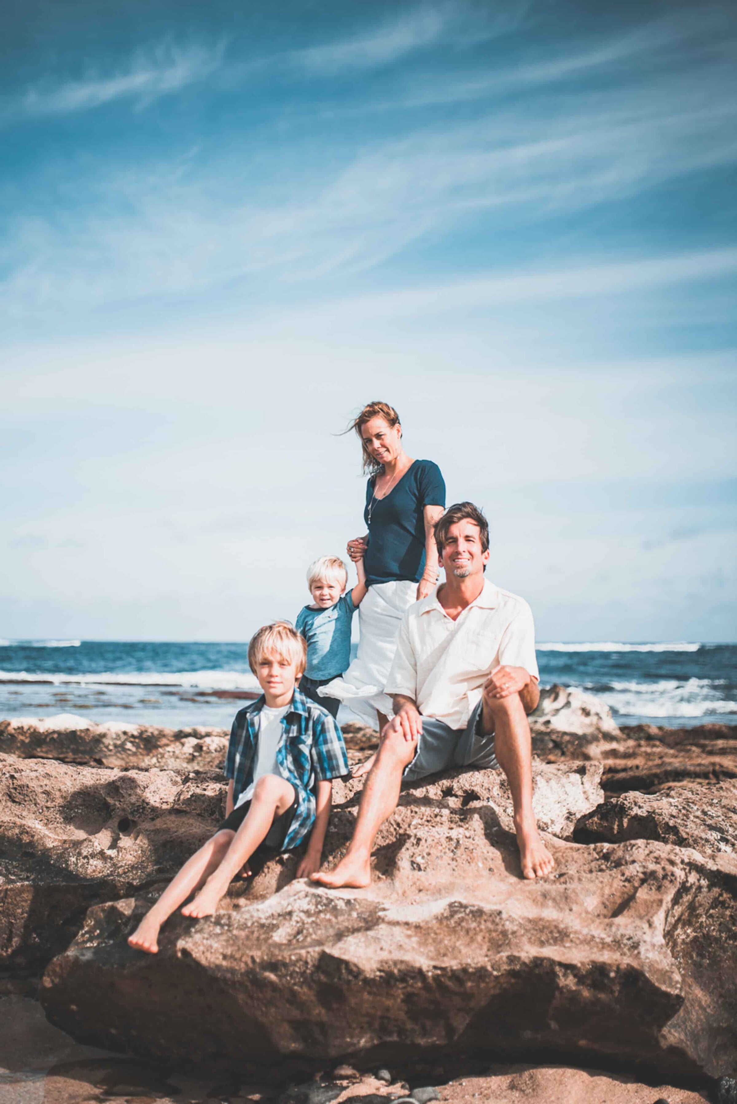 Family on coastal lava rocks Family of four with two boys on coastal lava rocks