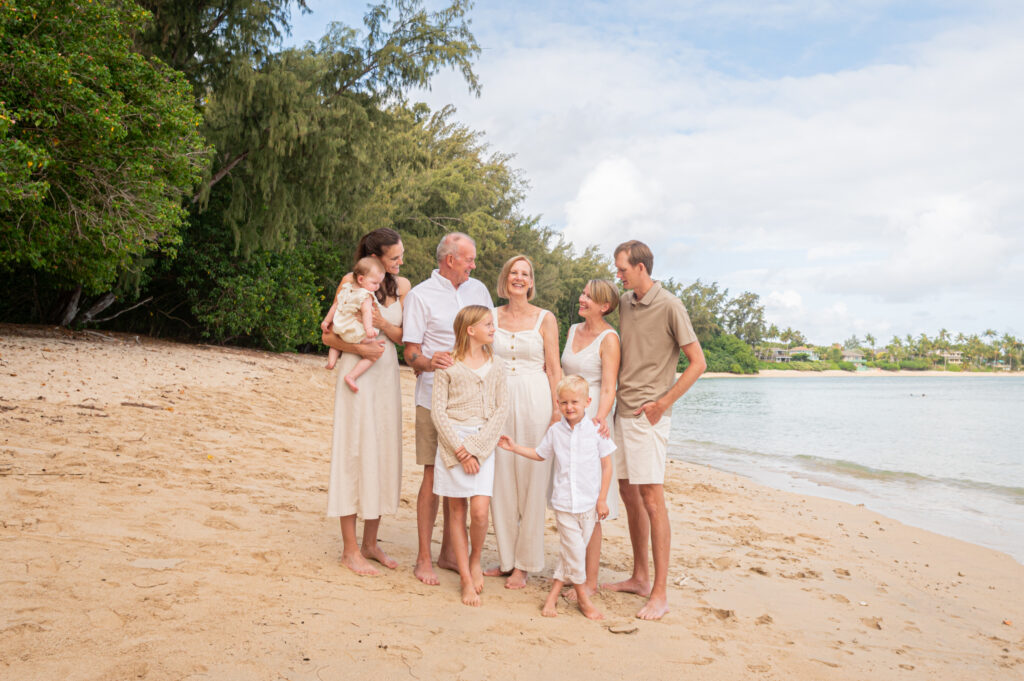 A multi-generational family smiling on a Hawaiian beach during a morning photography session, helping them decide the best time for their photos with the Hawaii family beach photography quiz.