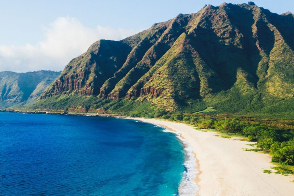Makua Beach Oahu, a remote live-action Moana filming location in Hawaii with steep green cliffs.